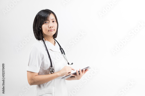Young asian nurse with a stethoscope using a digital tablet  isolated over white background.