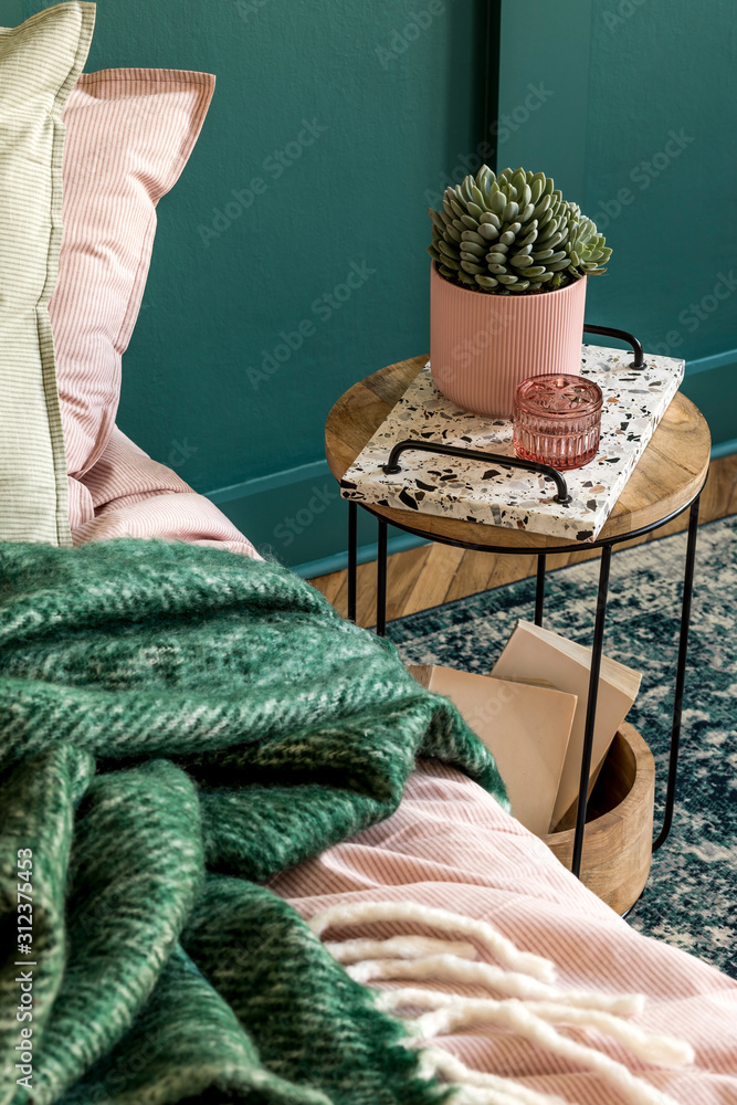 Stylish composition of bedroom interior with lastrico tray with coffee and elegant personal accessories. Beautiful pink and green bed sheets, blanket and pillow. Template Design home staging. Close up