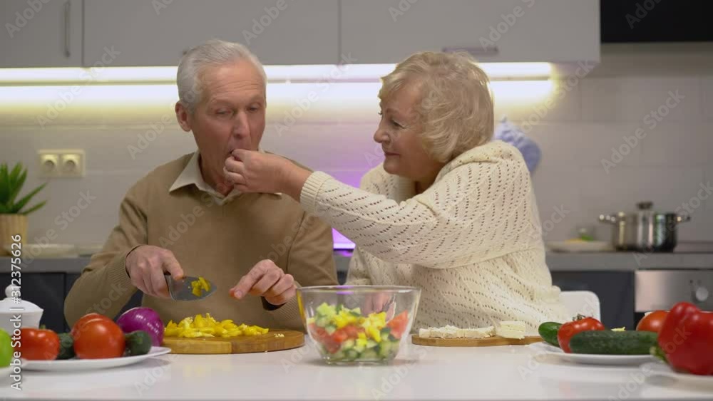 Senior man and woman cooking delicious healthy meal in kitchen, happy together Senior man and woman cooking delicious healthy meal in kitchen, happy together