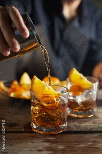Tasty alcoholic old fashioned cocktail with orange slice. photo