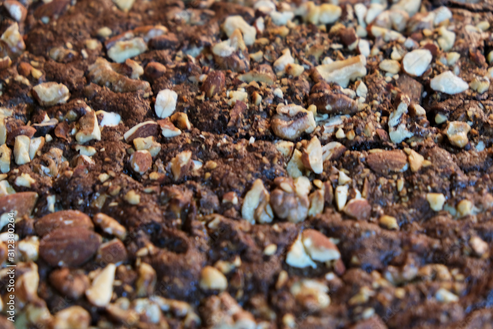 close up cenital view of a brownie dessert with nuts and almonds close up cenital view of a brownie dessert with nuts and almonds
