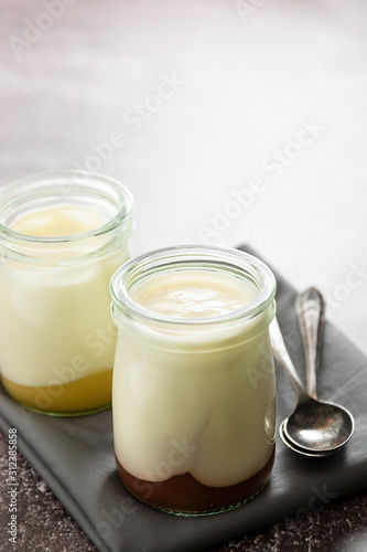 Fresh yogurt in glass jar with fruit jam. Healthy food, milk diary.