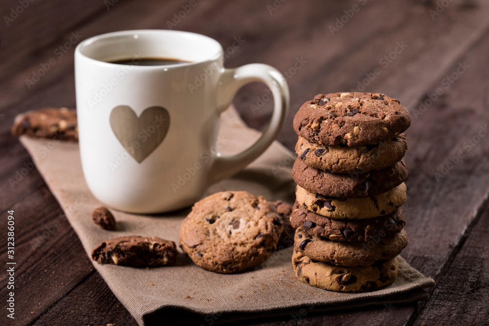 Cup of coffee with heart and chocolate chip cookies on rustic wooden background. Cup of coffee with heart and chocolate chip cookies on rustic wooden background.