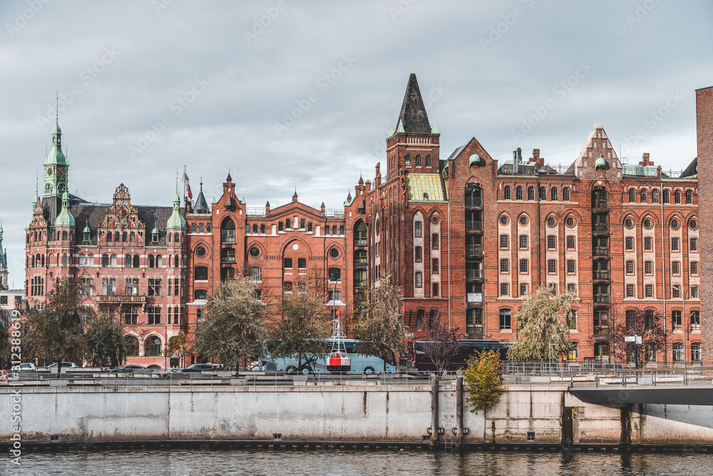 Fototapeta premium Speicherstadt red brick houses in Hafencity with cloudy sky, Hamburg, Germany