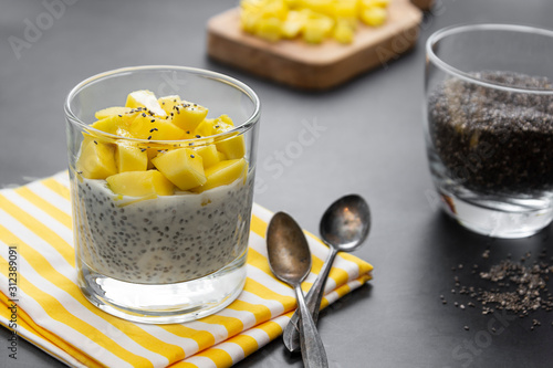 Coconut Chia seed pudding with pineapple, dark background copy space. Healthy food breakfast.