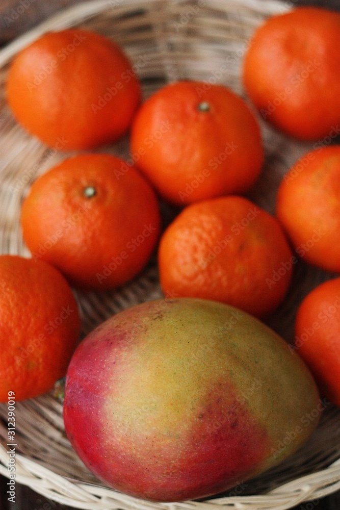 Fresh mango and tangerines on the table