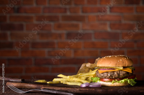 Fresh burger on wooden table and brick wall background