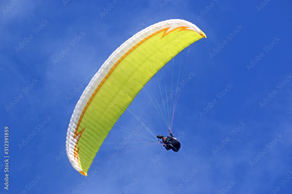 Paraglider flying wing in a blue sky Paraglider flying wing in a blue sky