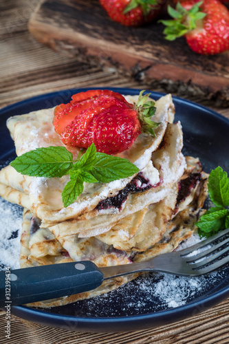 Polish pancakes with jam, cheese and strawberries.