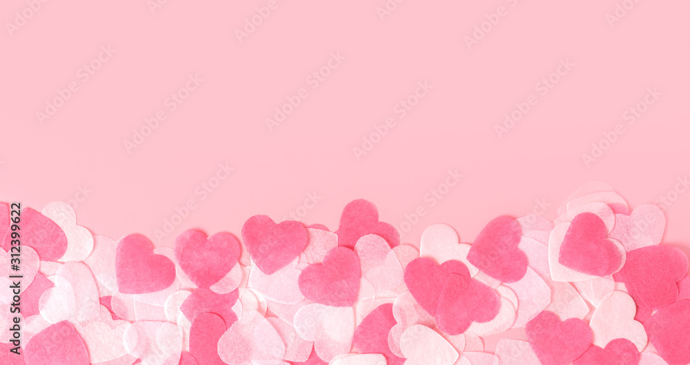 Pink hearts made of paper on a pink background, top view. Delicate pastel pink background with hearts for Valentine's day or wedding. Love and romance