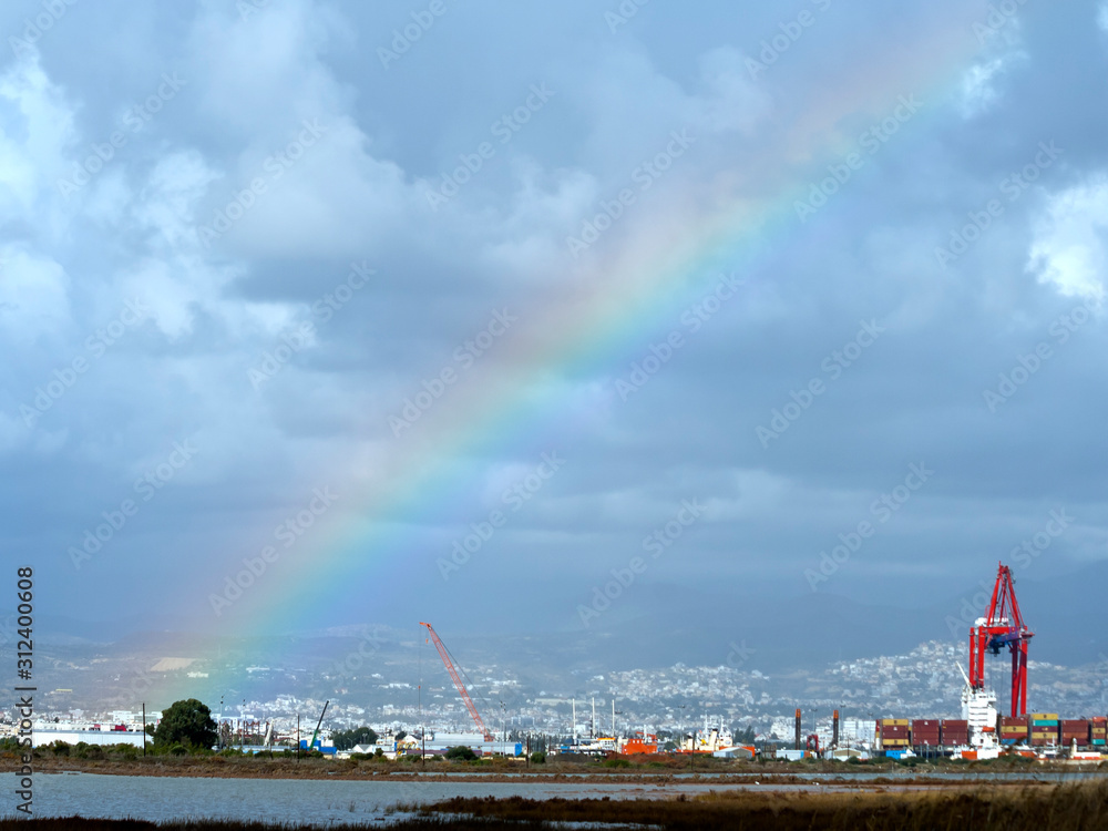Rainbow in the sky, lake and cityscape