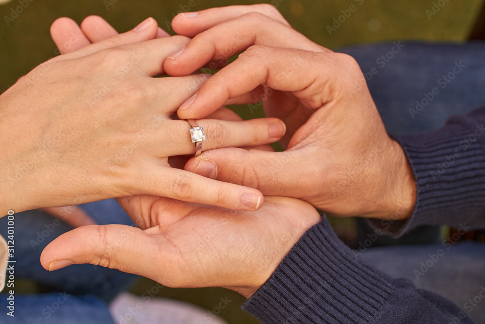Man hands putting ring on woman Man hands putting ring on woman