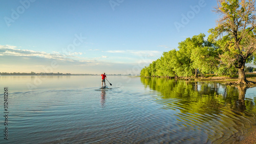 paddling stand up paddleboard on a lake