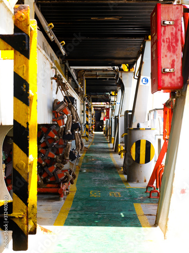 Main deck of cargo container ship. View of different cargo and safety equipment on the deck.