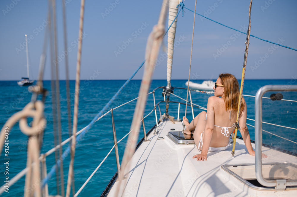 Pretty blonde girl is wearing sexy fashion swimsuit doing summer trip on a yacht. Pretty blonde girl is wearing sexy fashion swimsuit doing summer trip on a yacht.