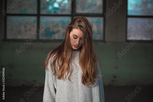 Portrait of cute, redhead teenage girl in gray sweater. Human emotions