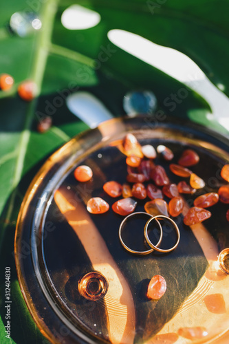 Wedding rings at the ceremony on a beautiful sheet of monstera