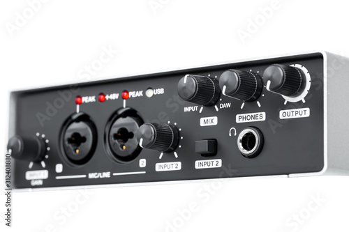 USB Audio interface front panel with volume and channel mix controls, external sound card black color isolated on white background close up.