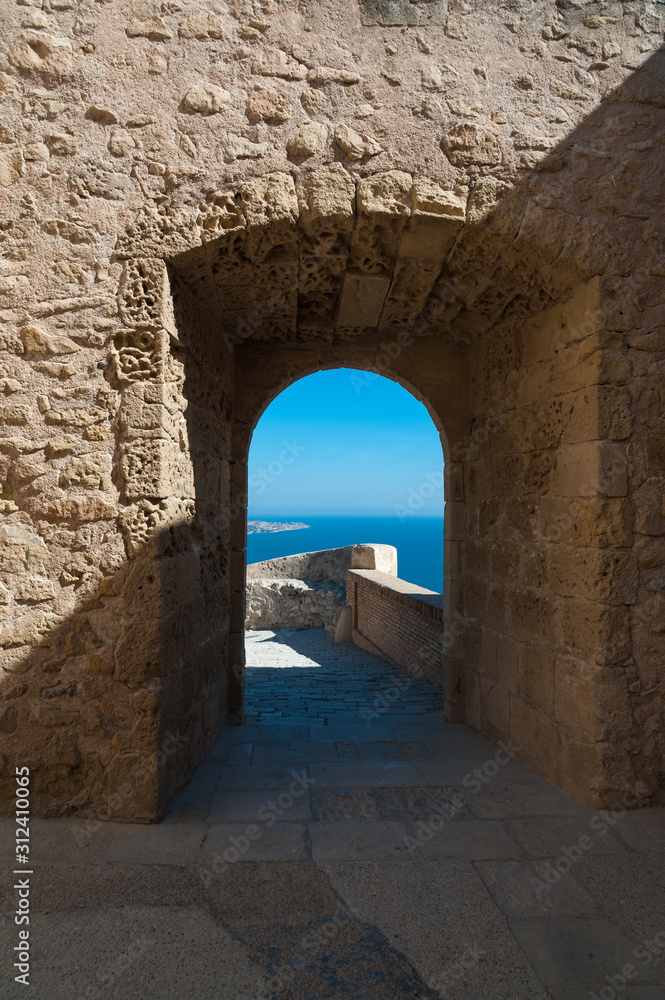 View to the sea through a medieval castle archway