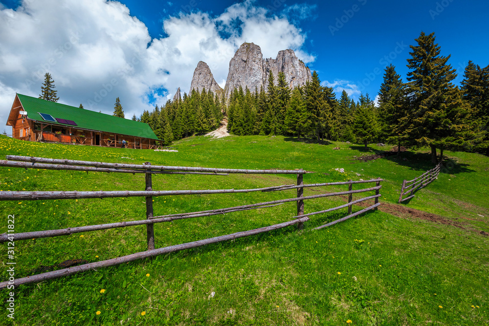 Idyllic summer landscape with high rocks and wooden shelter, Romania