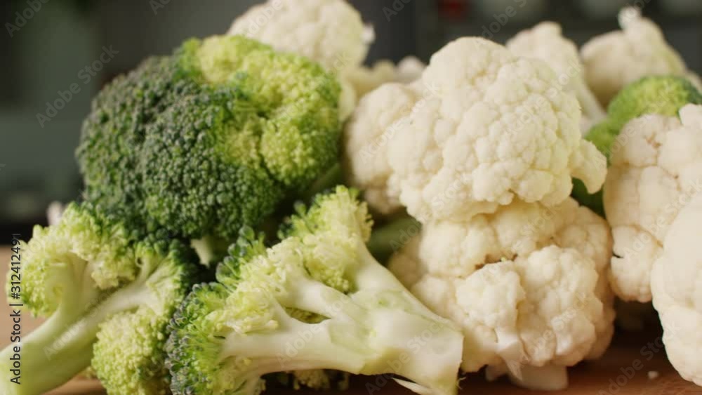 broccoli and cauliflower on wooden board in kitchen, close up broccoli and cauliflower on wooden board in kitchen, close up