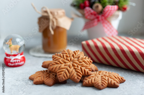  gingerbread cookie in the form of stars with christmas gifts and with a jar of salted caramel on a white background with christmas composition