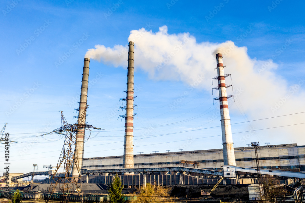 Heavy industrial coal powered electricity plant with pipes and smoke in black and white