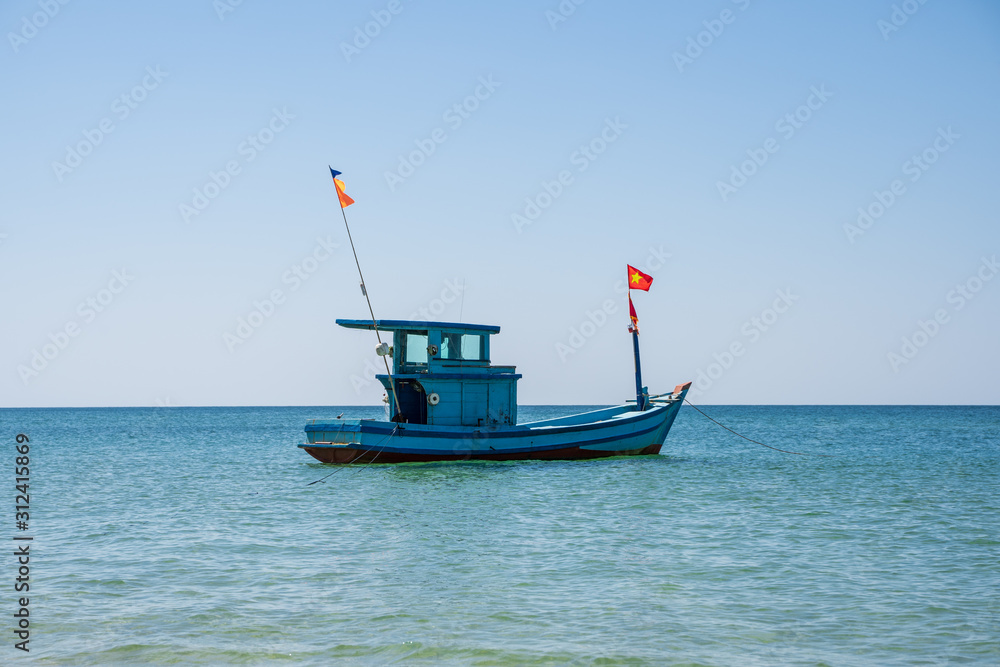 Wooden fisher motor boat with a Vietnamese flag