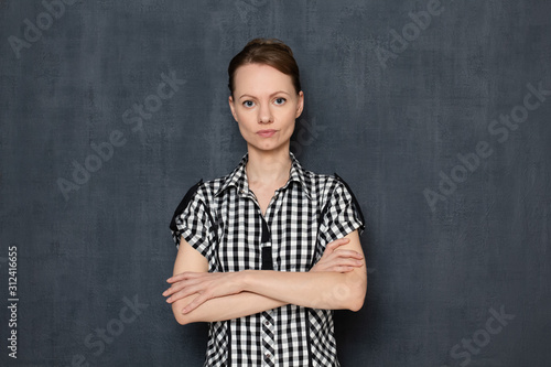 Portrait of serious focused young woman holding arms crossed on chest © Andrei Korzhyts