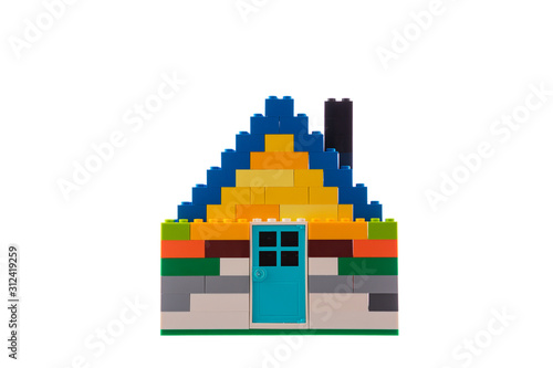 House made of classic building blocks, white studio background.