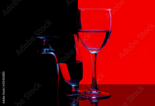 glass of red wine and bottle on black background