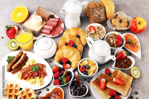 Breakfast served with coffee, orange juice, croissants, cereals and fruits. Balanced diet. Continental breakfast with granola and fruits