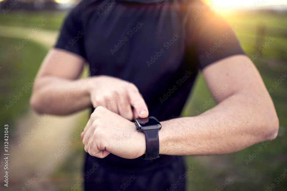 man in black sportswear running down a road in the middle of nature