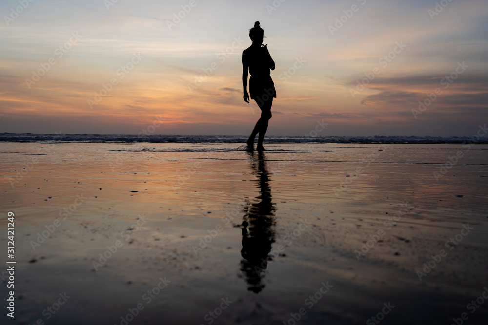 Silhouette of a moving girl walking on the water