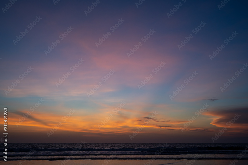 Orange clouds at ocean sunset