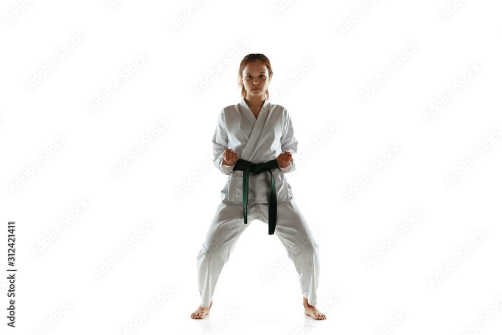 Confident junior in kimono practicing hand-to-hand combat, martial arts. Young female mongol fighter with green belt training on white studio background. Concept of healthy lifestyle, sport, action. Confident junior in kimono practicing hand-to-hand combat, martial arts. Young female mongol fighter with green belt training on white studio background. Concept of healthy lifestyle, sport, action.