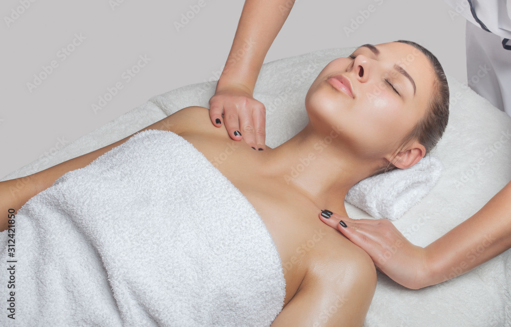 Masseur makes a relaxing massage on the face, neck, shoulders and collarbones of a young beautiful woman in a spa. Cosmetology and massage concept. Masseur makes a relaxing massage on the face, neck, shoulders and collarbones of a young beautiful woman in a spa. Cosmetology and massage concept.