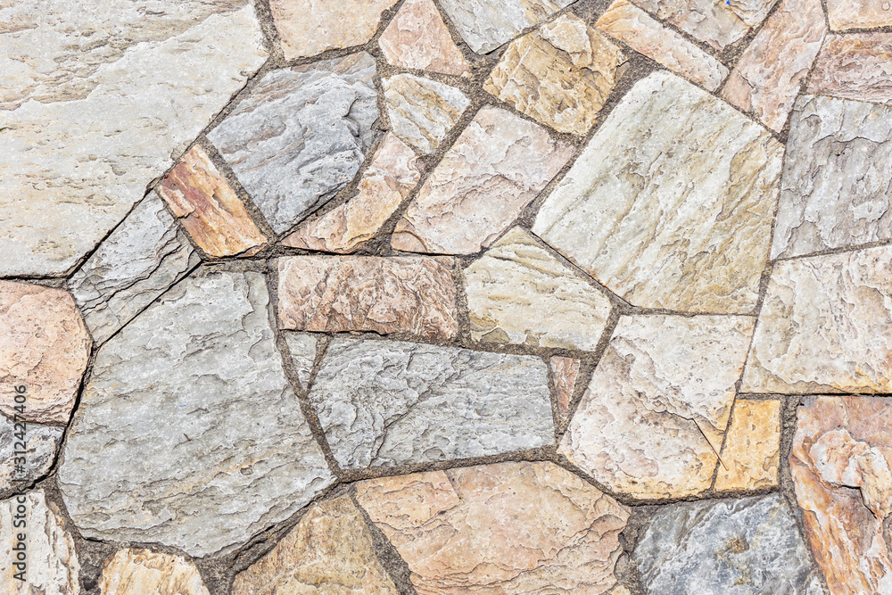 Gray concrete surface with uneven cracked stones. Grunge rocks decorative interior wall texture. Gray concrete surface with uneven cracked stones. Grunge rocks decorative interior wall texture.