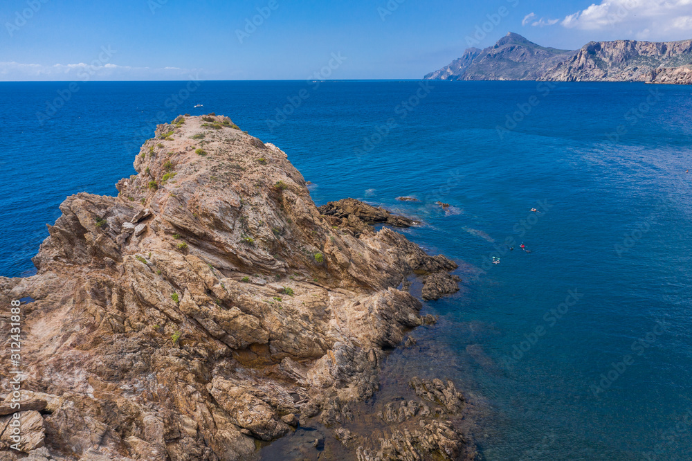 aerial view of the rocky cape surrounded by turquoise water