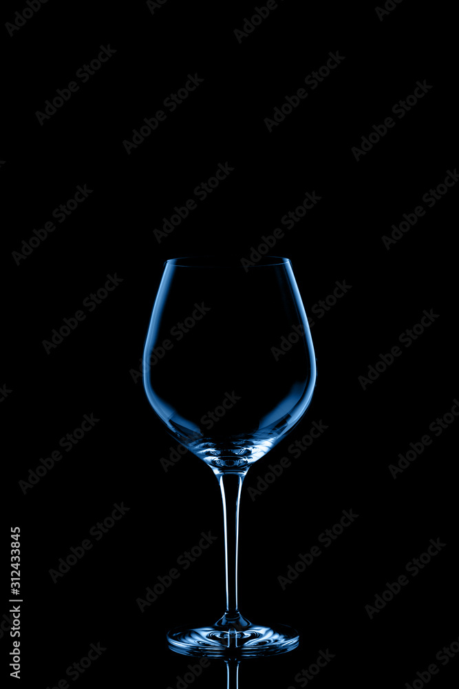 Red wine glass toned in classic blue on the dark background.. Fine cristal glassware concept. Vertical Red wine glass toned in classic blue on the dark background.. Fine cristal glassware concept. Vertical
