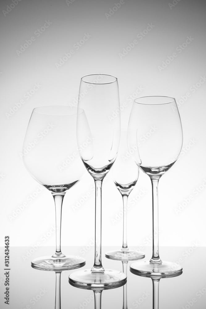 Glassware selection with wine, champagne and liquour glasses. Fine cristal glassware concept. Vertical, lightly toned