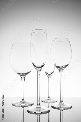 Glassware selection with wine, champagne and liquour glasses. Fine cristal glassware concept. Vertical, lightly toned