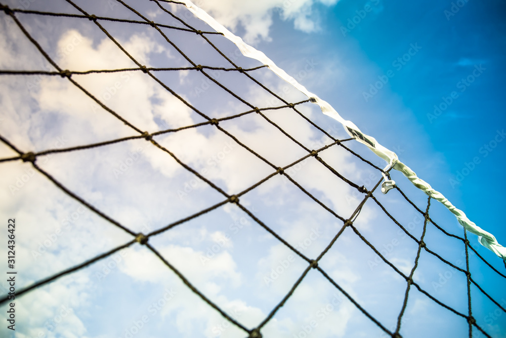 Sunny summer ball games background - beach volleyball or tennis net against serenity blue sky for sport events and holiday recreation backdrop such as in Rio de Janeiro, Brazil Sunny summer ball games background - beach volleyball or tennis net against serenity blue sky for sport events and holiday recreation backdrop such as in Rio de Janeiro, Brazil
