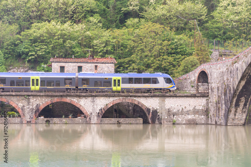 Bridge of a devil. Bridge over the river in Tuscany. Built in the 11 century. The train passes under the bridge.