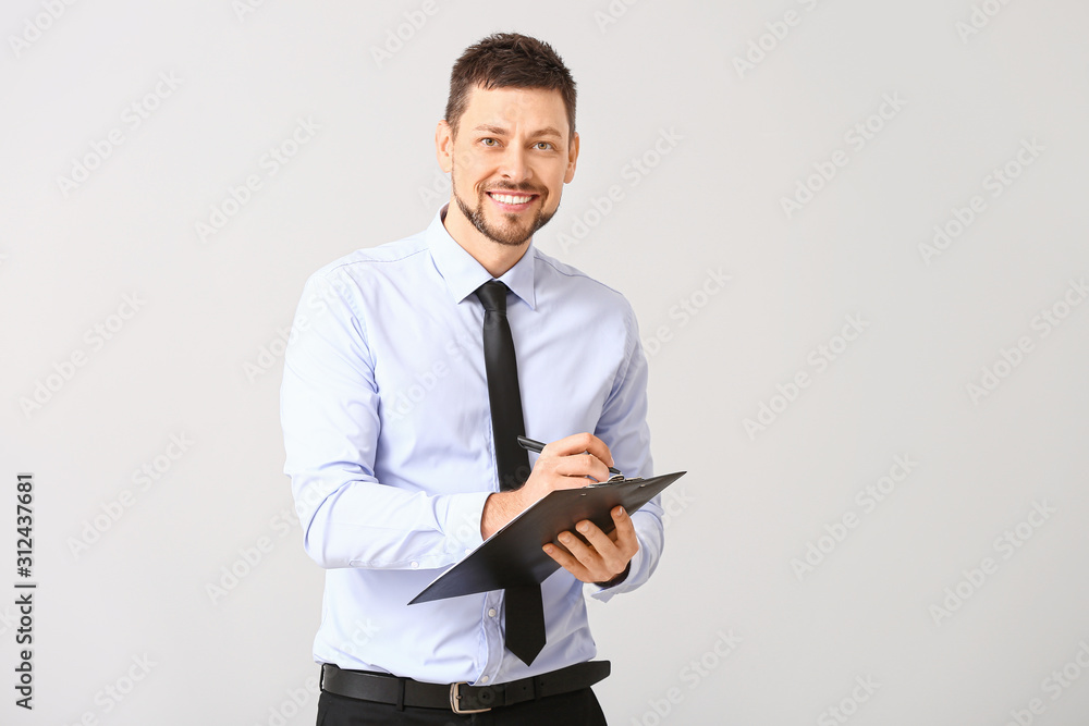 Handsome businessman with clipboard on white background Handsome businessman with clipboard on white background