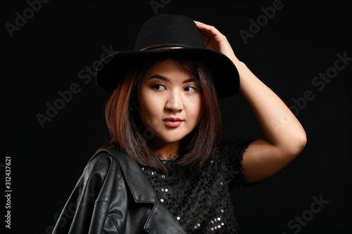 Portrait of young Asian woman on dark background © Pixel-Shot