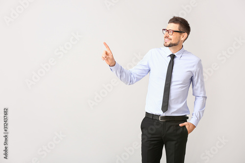 Handsome businessman pointing at something on white background