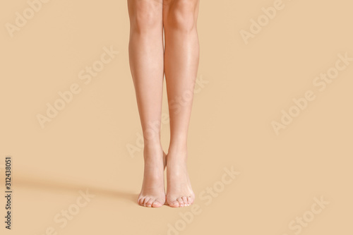 Legs of beautiful young woman on color background © Pixel-Shot