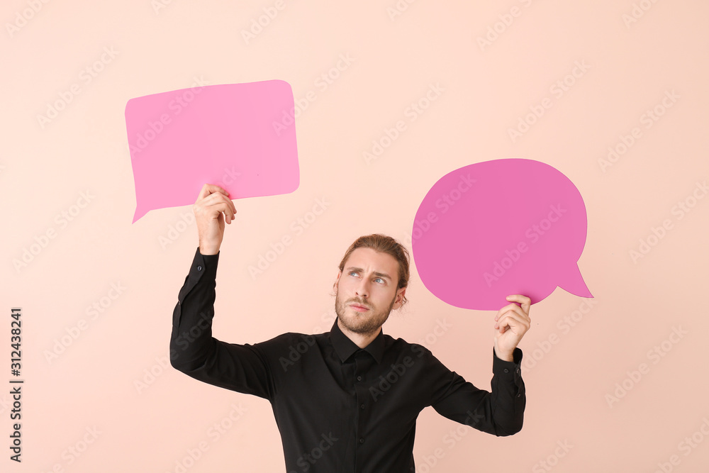 Young man with different blank speech bubbles on color background Young man with different blank speech bubbles on color background