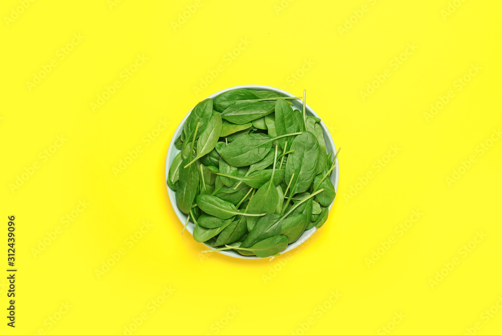 Plate with fresh spinach on color background Plate with fresh spinach on color background